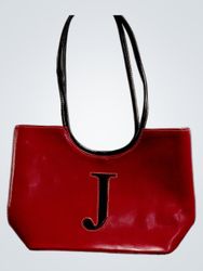 Red handbag with a large black J on the front
