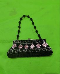 Black beaded clutch with pink floral embellishment..