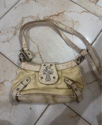 Cream colored handbag with jeweled cross embellish..