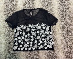 Schwarzes transparentes Oberteil mit weißer Blumen..