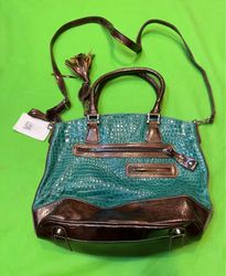 Bolsa texturizada verde e marrom com franjas e tac..