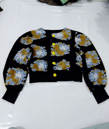 Schwarze Strickjacke mit abstraktem Muster und gelben Knöpfen