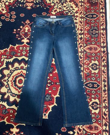 Blaue Flare-Jeans mit verzierten Taschen