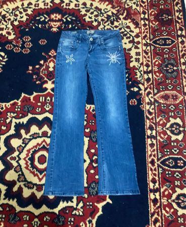 Blaue Flare-Jeans mit bestickten Taschen