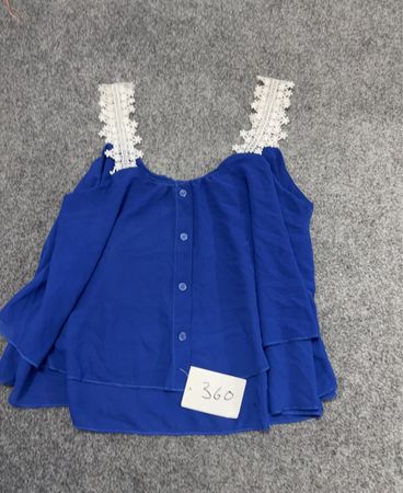Blaues Oberteil mit weißen Spitzen-Trägern und Knöpfen
