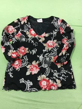 Schwarzes Mesh-Oberteil mit floralem Druck, V-Ausschnitt und langen Ärmeln.