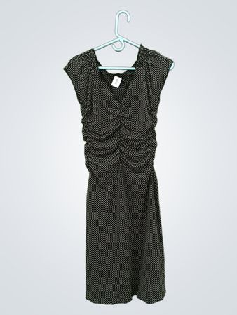 Schwarzes und weißes gepunktetes gerafftes Kleid