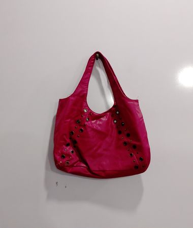 Pink hobo bag with decorative grommets