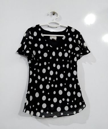 Karin Stevens schwarze Bluse mit kurzen Ärmeln und weißen Punkten