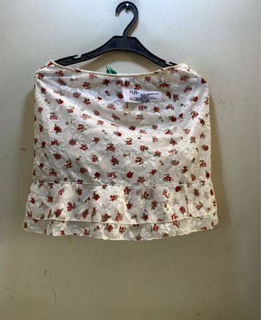 Weißer Spitzenrock mit rotem Blumenmuster und Rüschensaum