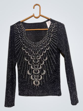 Glitzerndes schwarzes Langarmoberteil mit weißer Verzierung