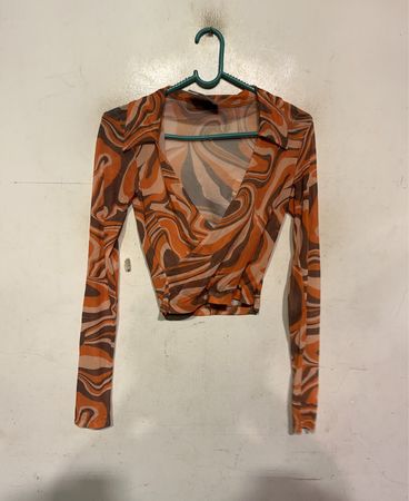 Langärmlige Wickeloberteil mit orange und braunem Wirbelmuster und Kragen aus Mesh