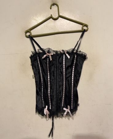 Schwarzes Korsett mit rosa Schleifen und Spitzenbesatz
