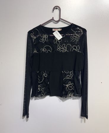 Schwarzes Langarmoberteil mit floralem Schmuck.