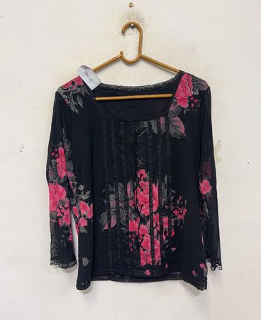 Schwarzes Langarmoberteil mit pinkfarbenem Blumenmuster und Spitzenbesatz