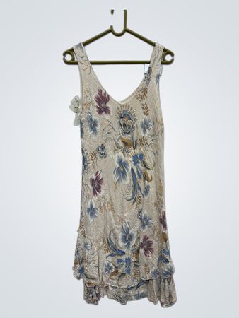 Beiges ärmelloses Kleid mit floralem Druck und Rüsche am Saum.