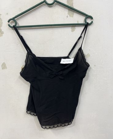 Schwarzes Top mit Spitzenbesatz und Schleifendetail