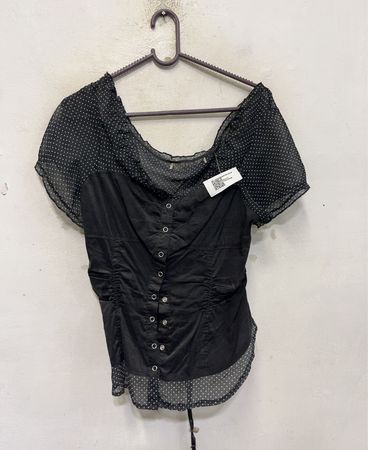 Schwarze Bluse mit transparenten Tupfenärmeln, geraffter Vorderseite und Schnürung am Rücken