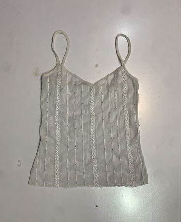 Durchsichtiges weißes Tanktop mit Pailletten- und Spitzenverzierungen.