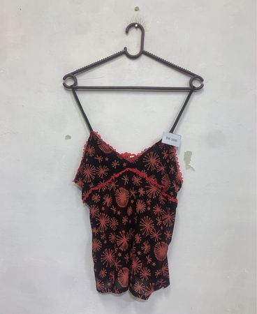 Schwarzes Trägershirt mit rotem Strahlenmuster und rotem Spitzenrand.