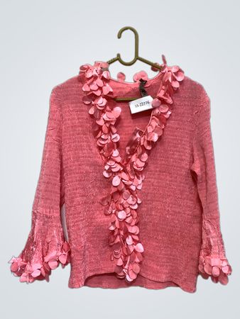 Rosa Bluse mit floralem Schmuck.