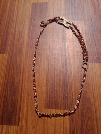 Gold chain necklace with red and white accents