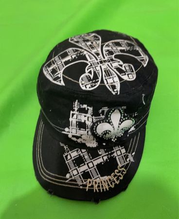 Schwarze Kappe mit "PRINCESS"-Text und Fleur-de-lis-Grafik