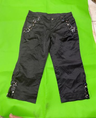 Schwarze Capri-Hosen mit verzierten Taschen und Saum