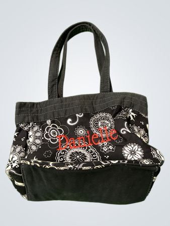 Schwarze und weiße Blumen-Tasche mit "Danielle" in Rot gestickt.