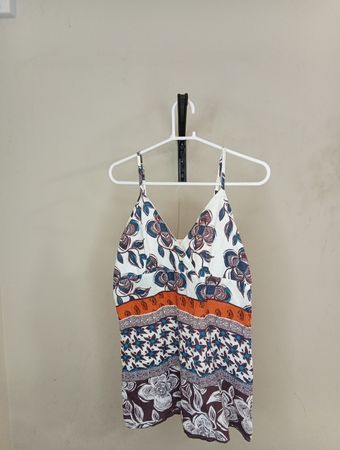 Weißes Top mit Blumenmuster und orangefarbener Borte