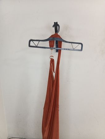Oranges Gewebe über einem Kleiderbügel