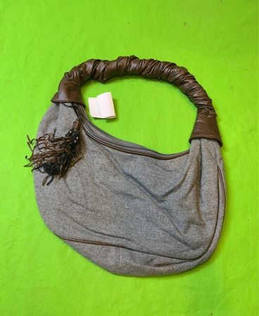 Graue Hobo-Tasche mit braunen Ledergriffen und Quaste