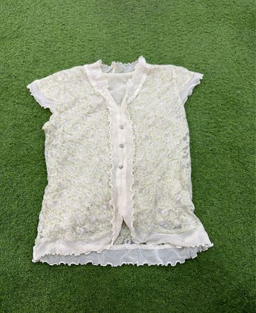 Top curto de mangas curtas em renda branca transparente com padrão floral verde