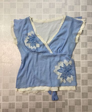 Blue top with white trim and floral embroidery