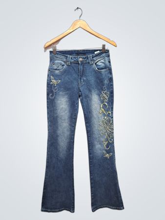 Jean flare bleu avec des papillons et des fleurs brodés.
