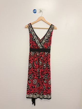 Ärmelloses rotes Kleid mit Blumenmuster und schwarzem Gürtel