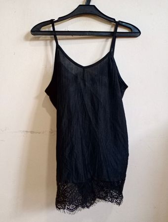 Schwarzes Spaghettiträgershirt mit Spitze.