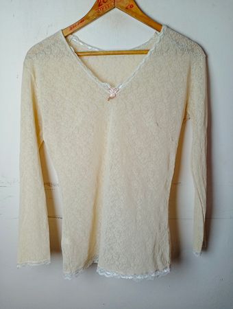 Durchsichtige Spitzenbluse mit langen Ärmeln und rosa Schleife