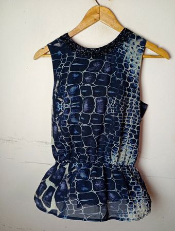 Ärmelloses blaues bedrucktes Top mit Perlenhalsabschluß