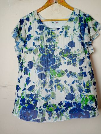 Weißes Oberteil mit floralem Druck und blauen Blumen