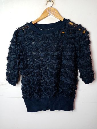 Schwarzer pullover mit floralen Verzierungen