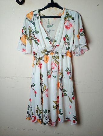 Weißes Kleid mit floralem Druck und fließenden Ärmeln