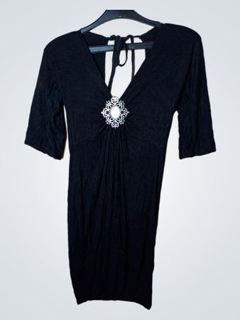 Schwarzes Kleid mit dekorativer Brosche