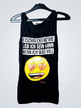 Schwarzes Tanktop mit dem Text "ERSCHRECKEND WIE LIEB ICH SEIN KANN WENN ICH WAS WILL" und einer Grafik mit Herzaugen-Emoji