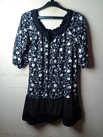 Schwarzes und weißes Kleid mit floralem Muster und Punkten am Saum