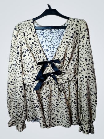 Bluse mit langen Ärmeln aus kremigem Stoff, mit Blumenmuster und schwarzer Schleifen-Applikation