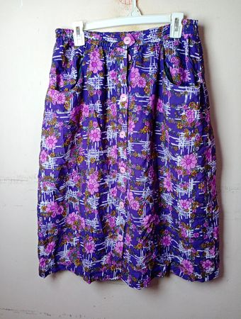 Lila Midirock mit Blumenmuster und rosa Knöpfen