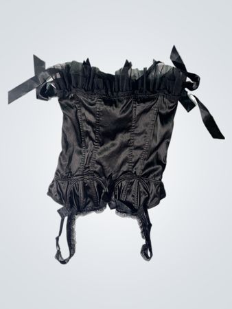 Schwarzes Korsett mit Rüschen und Bändern