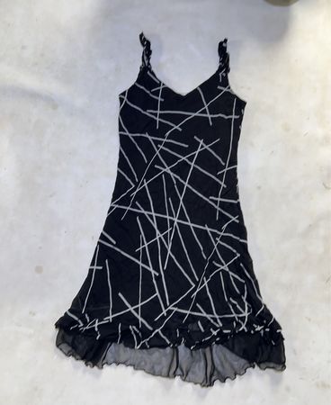 Black dress with white abstract lines and ruffled hem