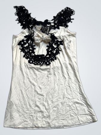 Weißes Trägershirt mit schwarzer Spitzenverzierung am Ausschnitt und Schleife